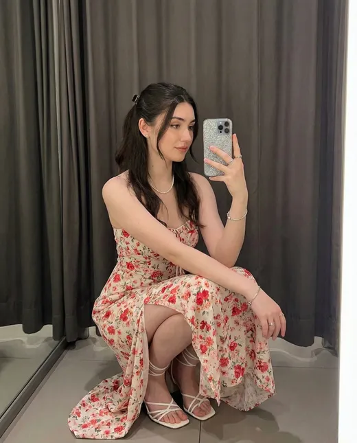 Dark-haired fictional AI character in a floral summer dress