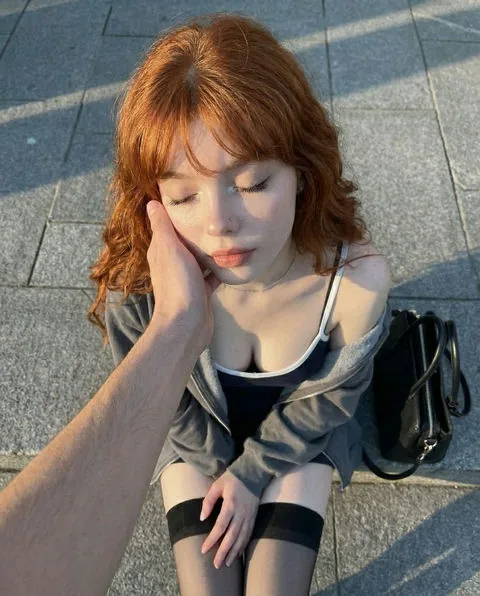 Red-haired fictional AI character outdoors